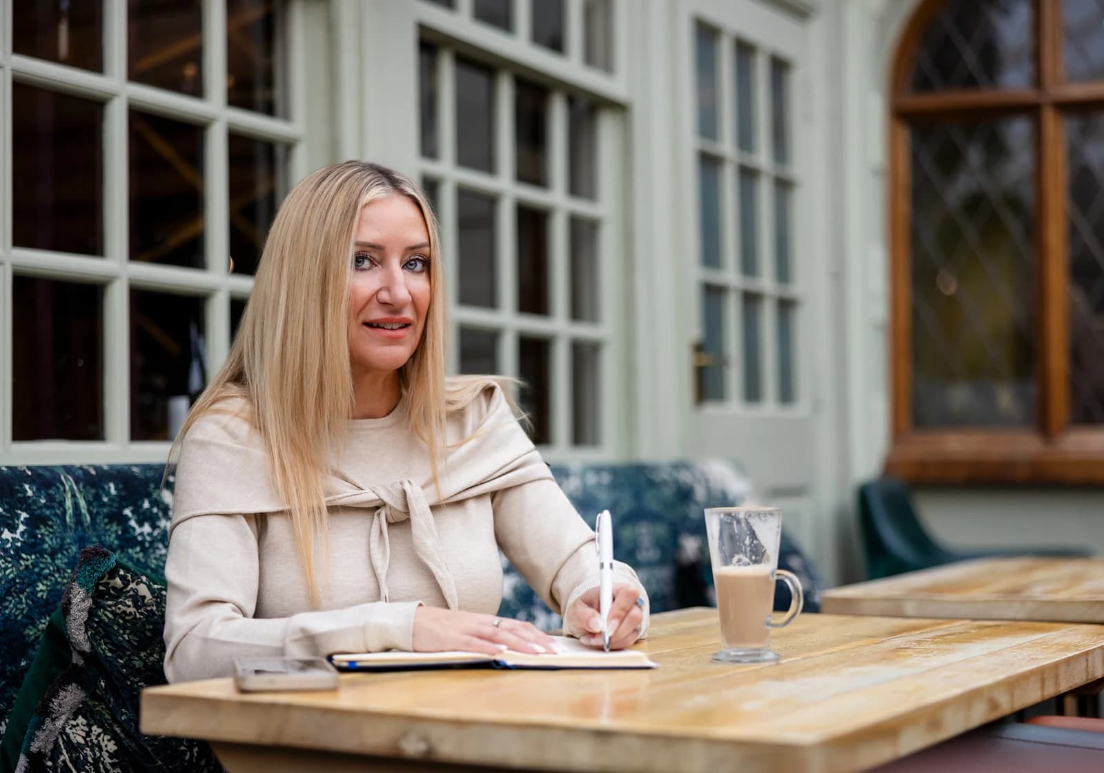 Gemma with an open notebook at a courtyard table