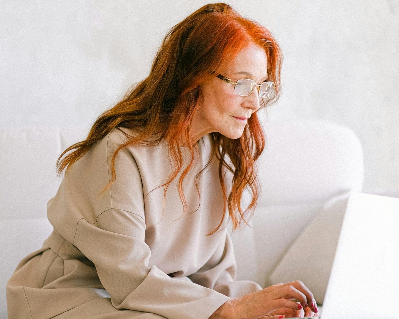 An older woman working at a laptop