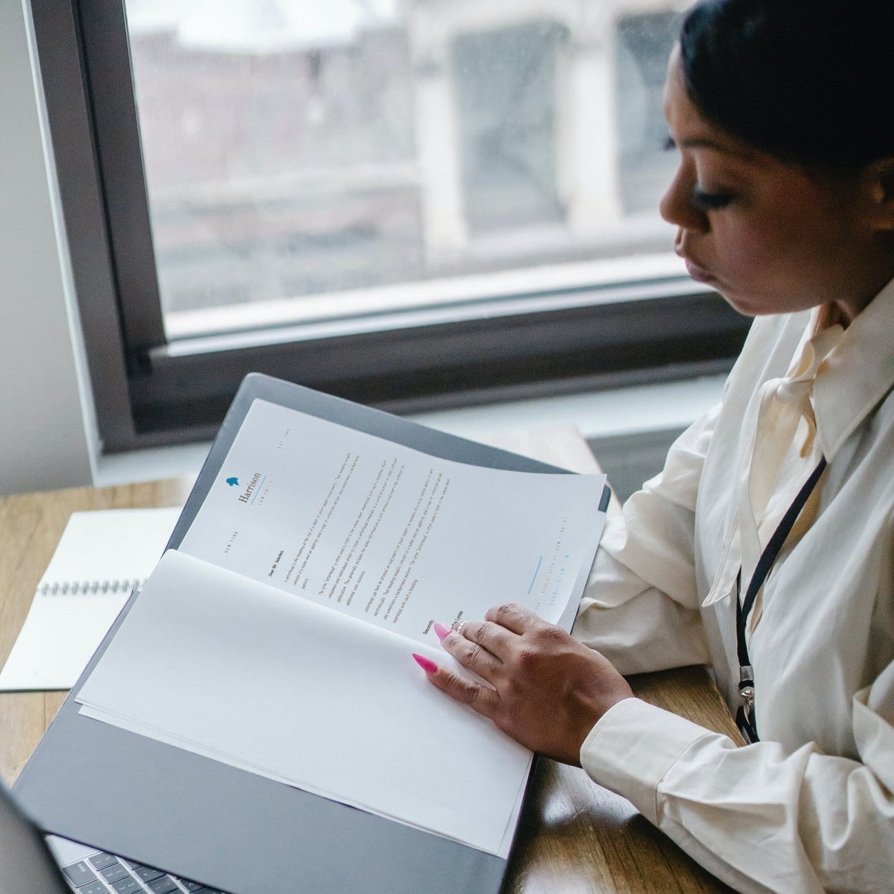 A woman at a desk reading a printed letter