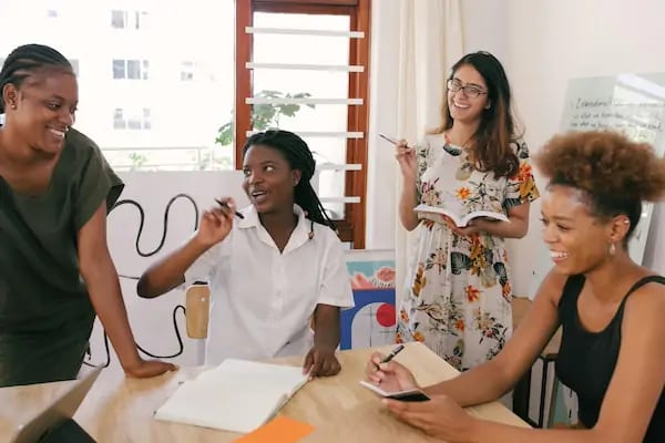 Four colleagues talking and laughing together around a table